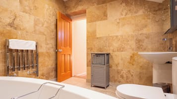 A bathroom with a bathtub, toilet, and sink.