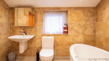 A bathroom with a sink, toilet, and bathtub.