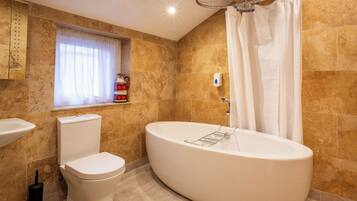 A modern bathroom with a freestanding bathtub, a toilet, and a sink.