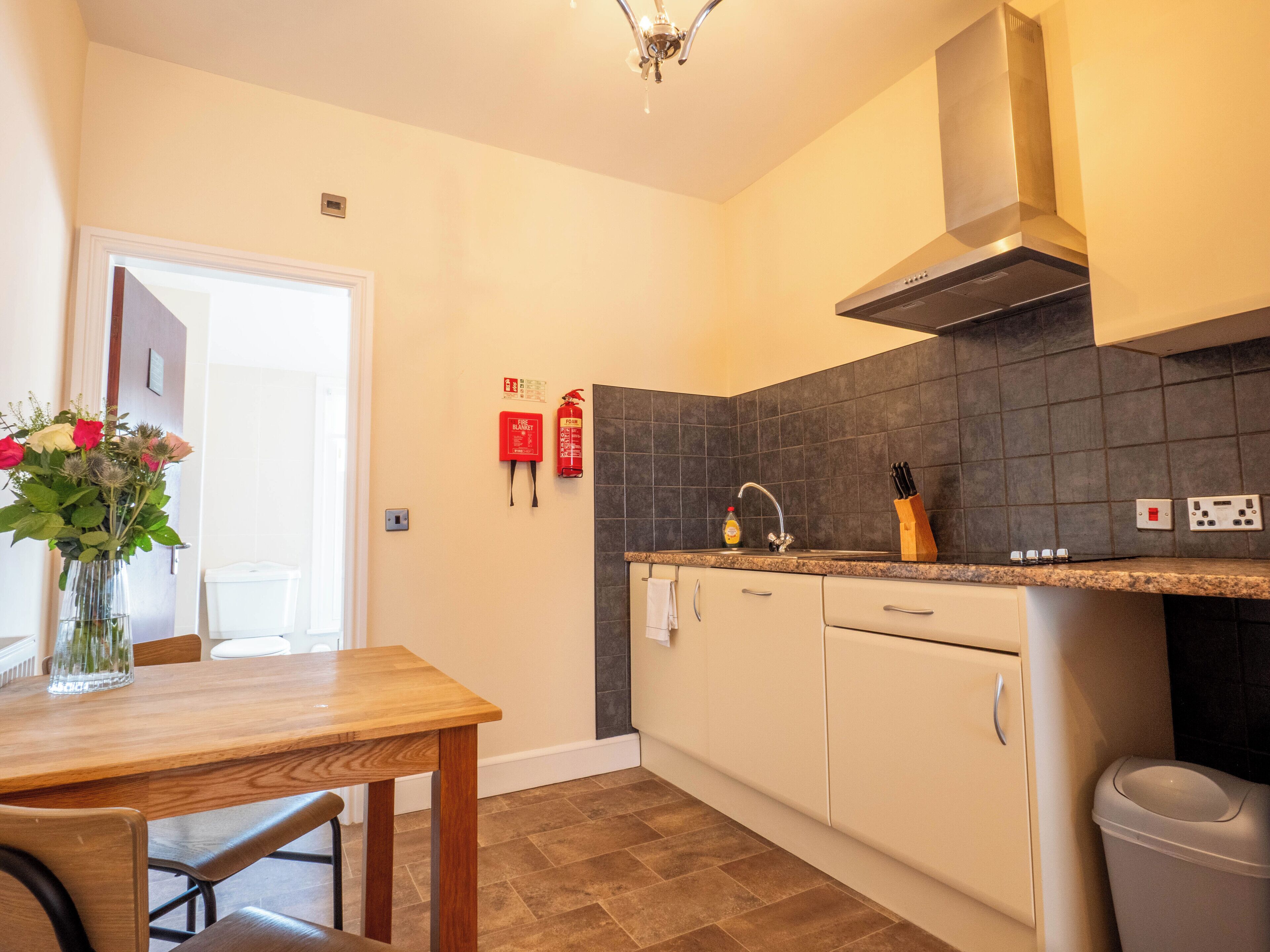 Una cocina moderna con una mesa y sillas de madera, un fregadero y una estufa.