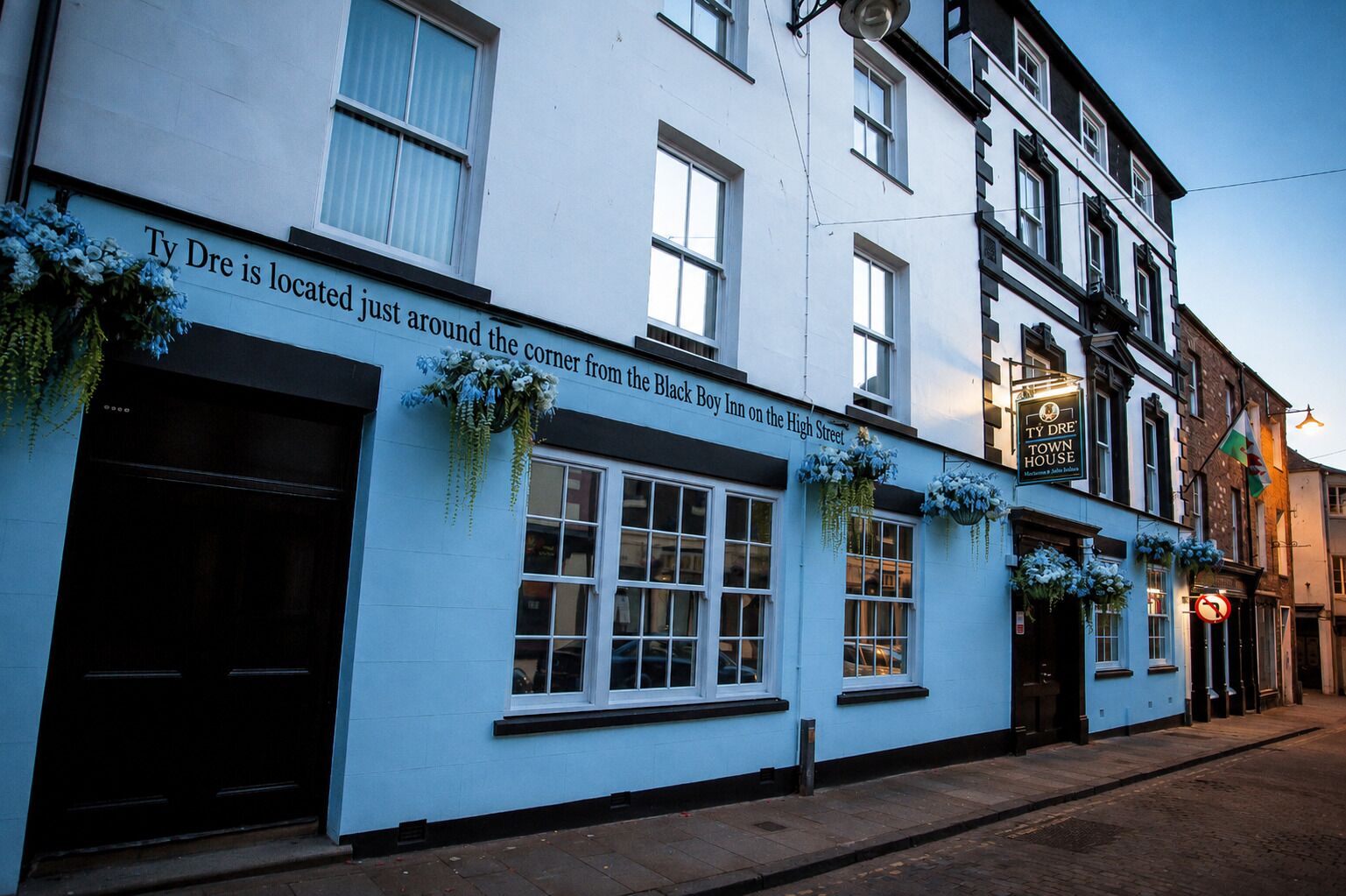 A traditional pub with a sign indicating its location near the Black Boy Inn on the High Street.