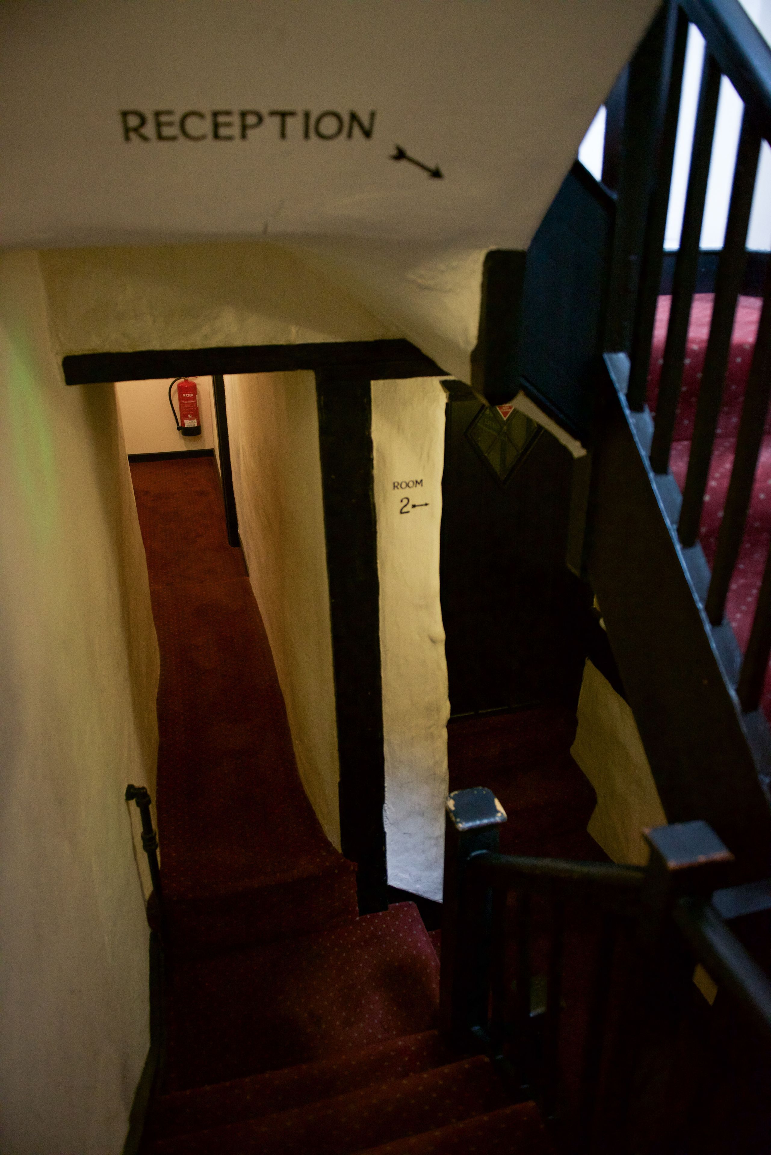 A staircase leading to a reception area with a sign above indicating 'RECEPTION'.