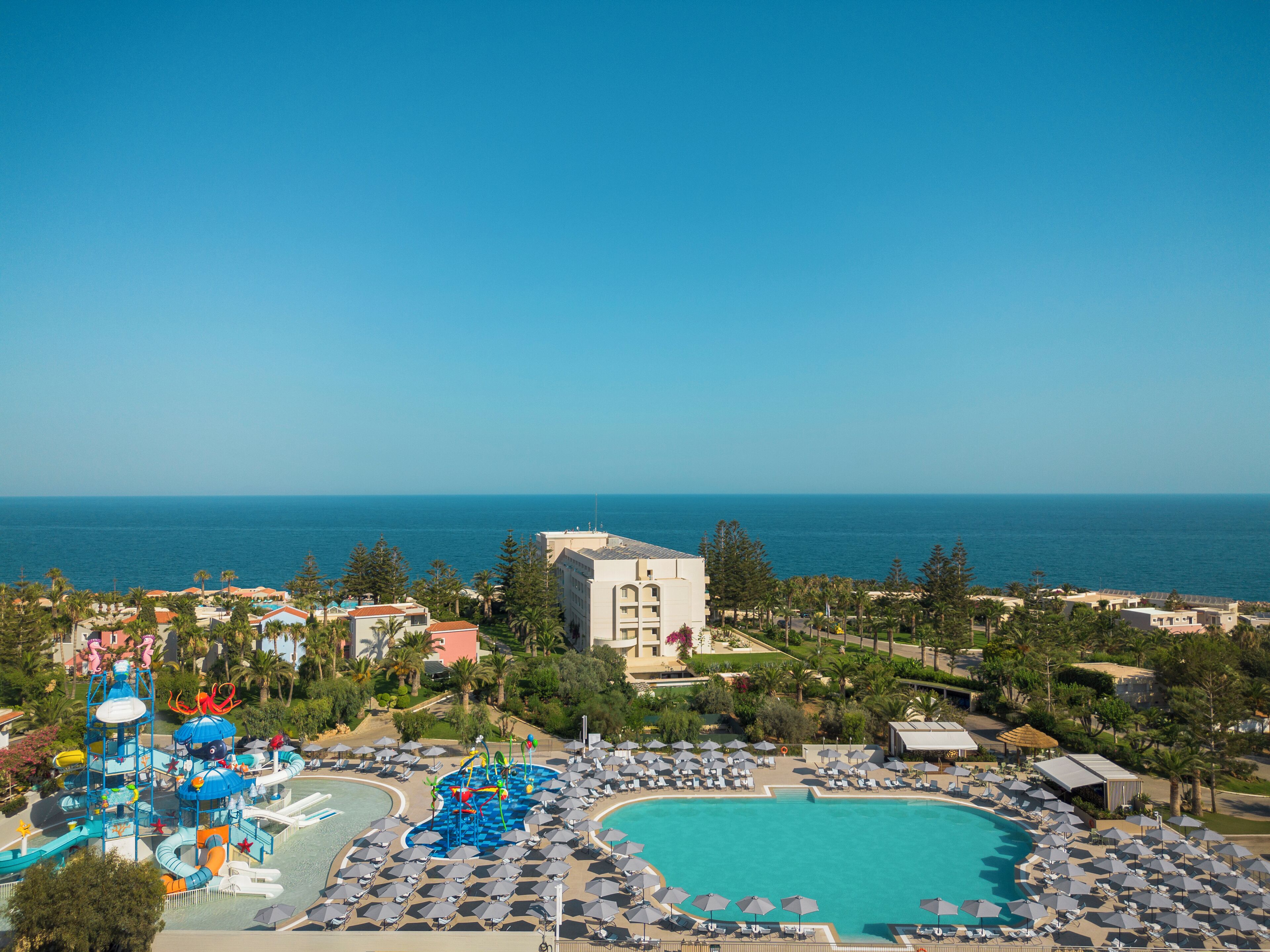 Un complejo turístico con una gran piscina, parque acuático y zona de playa.