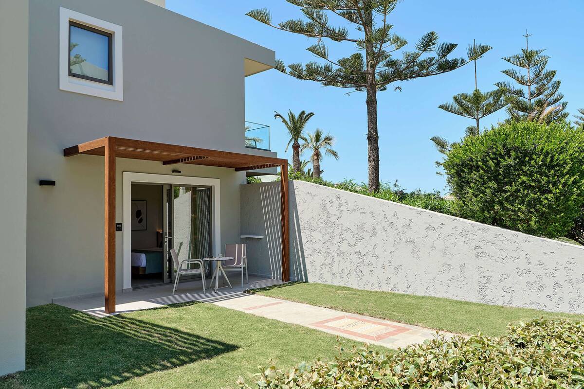 Une maison moderne dotée d’un patio couvert, d’un petit jardin et d’un toit en pente.