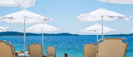 Sulla spiaggia, lettini da mare, ombrelloni, pallavolo