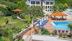 Ein Hotel mit Schwimmbad, Außenbereich und Spielplatz.
