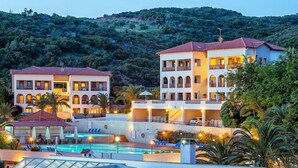 Ein Hotel mit mehreren Gebäuden, einem Schwimmbad und einer Bergkulisse.