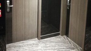 Quarto de hotel com duas portas, cada uma identificada com um número.