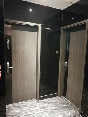 Habitación de hotel con dos puertas, cada una con un número.