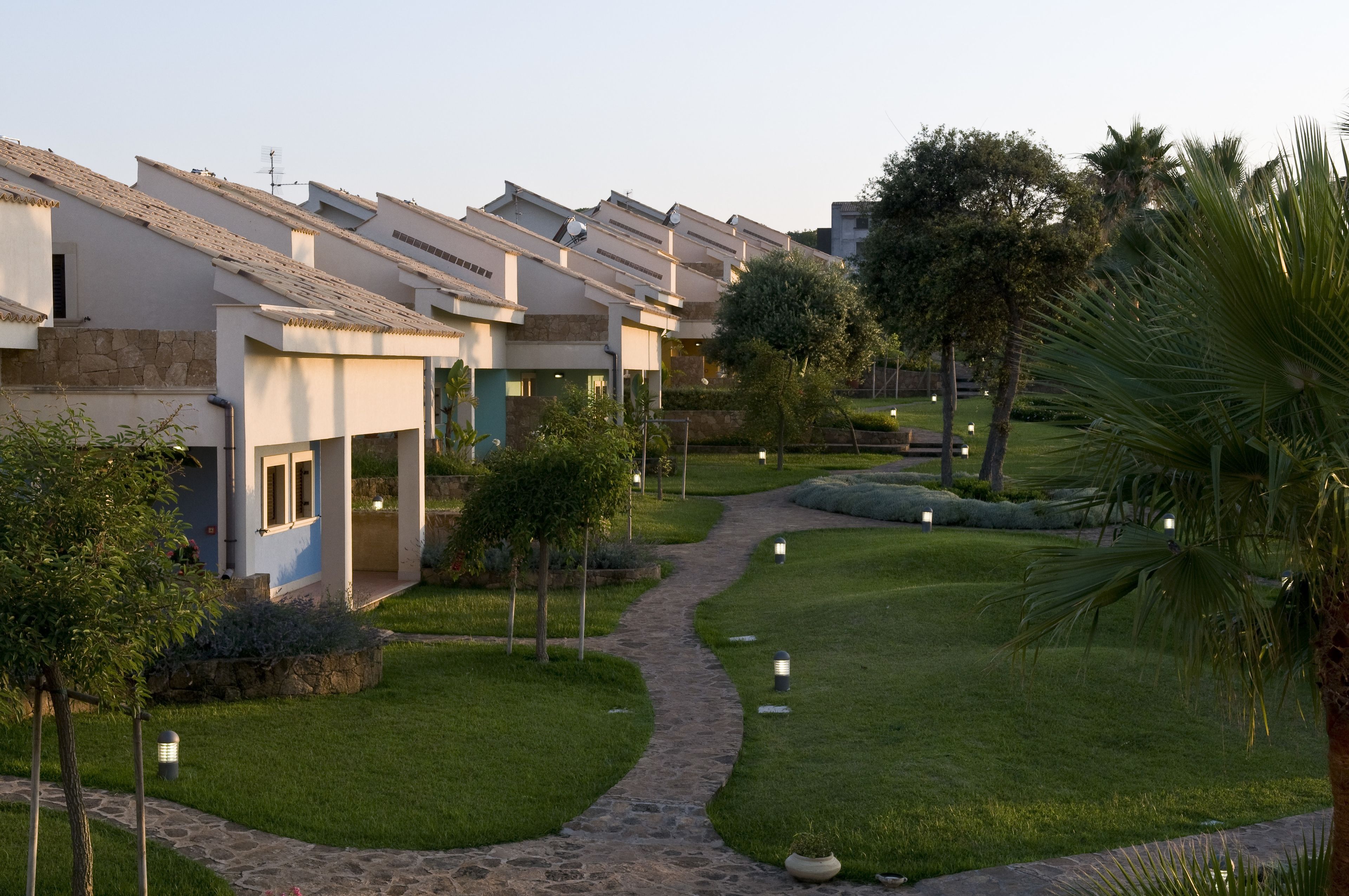 Een woonwijk met moderne huizen, een verhard pad en keurig onderhouden gazons.