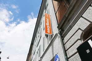 Located in a building with a mix of brick and plaster architecture, this hotel features a prominent sign and a visible window pattern.