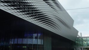 Un bâtiment moderne doté d’une façade géométrique originale et de grandes fenêtres.
