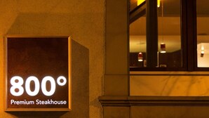 Une enseigne indiquant un restaurant de steaks haut de gamme, avec un affichage de la température à 800 degrés.