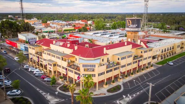 A multi-story hotel with a red roof, multiple floors, and a parking lot.