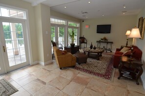 A spacious living room with a large window, a television, and a red sofa.
