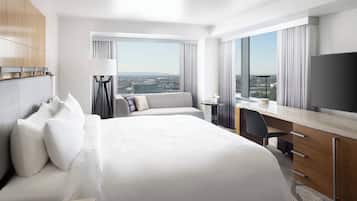 Una habitación de hotel con una cama grande, un escritorio y vistas a la ciudad.