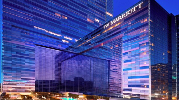 A JW Marriott hotel with a modern glass facade, outdoor pool, and well-lit signage. - JW Marriott Los Angeles L.A. LIVE (Los Angeles)