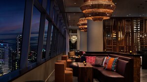 A modern interior with a seating area, large windows, and a city view. - JW Marriott Los Angeles L.A. LIVE (Los Angeles)
