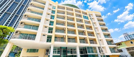 A multi-story hotel with a curved facade, large windows, and balconies.