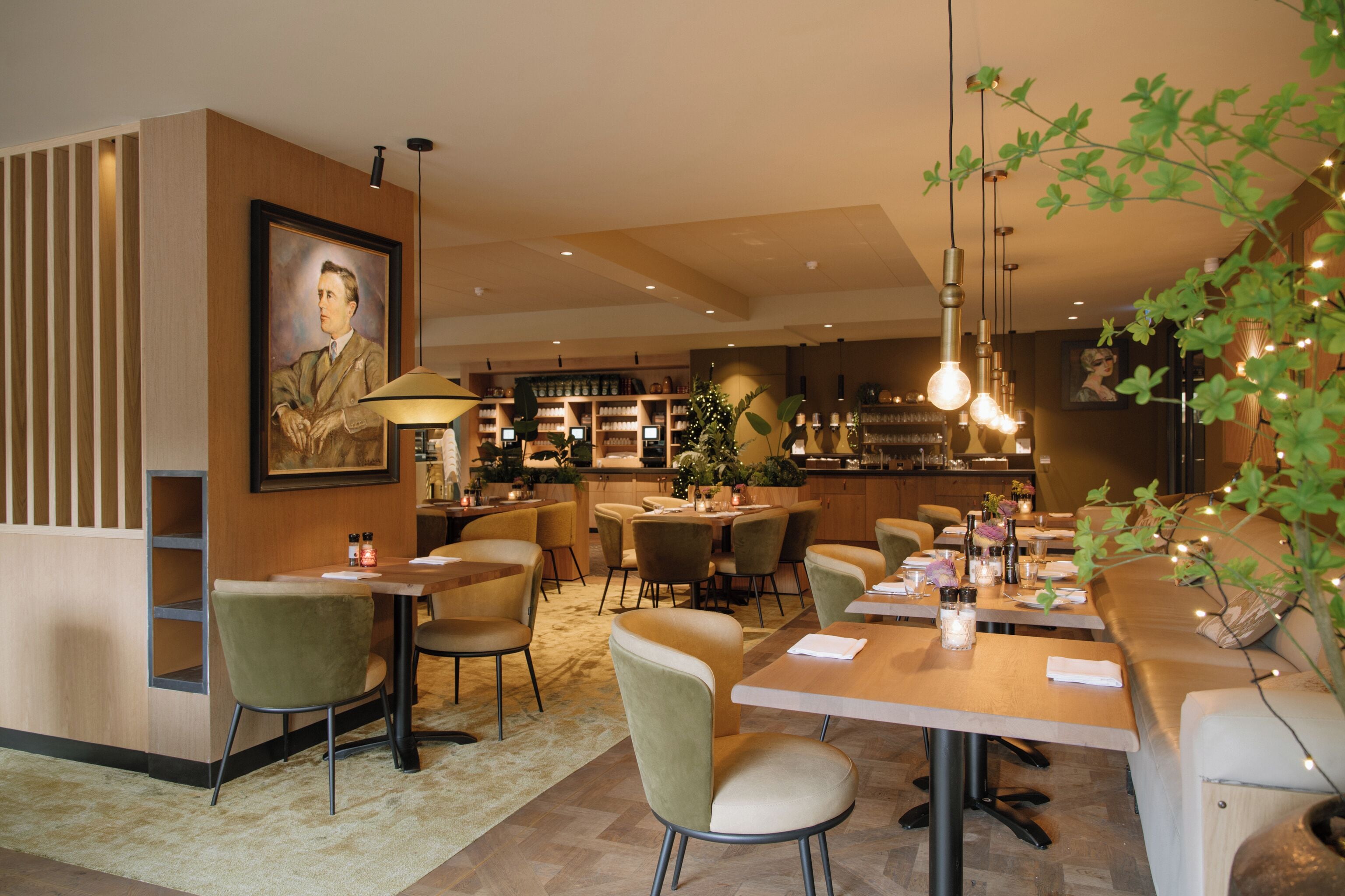 Un restaurante con paneles de madera, sillas tapizadas de verde y una zona de bar al fondo.