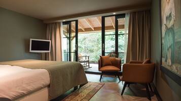A hotel room with a bed, a television, a chair, and a large window with curtains.