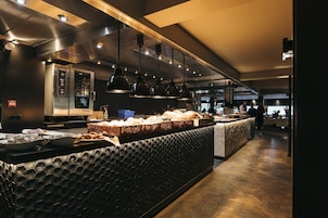 Una cocina moderna con electrodomésticos de acero inoxidable, encimera de textura hexagonal e iluminación colgante.