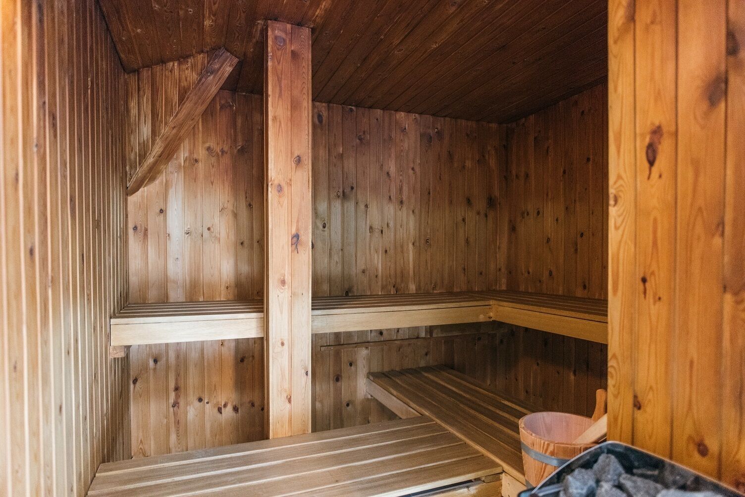 Un sauna avec des murs et des bancs en bois.