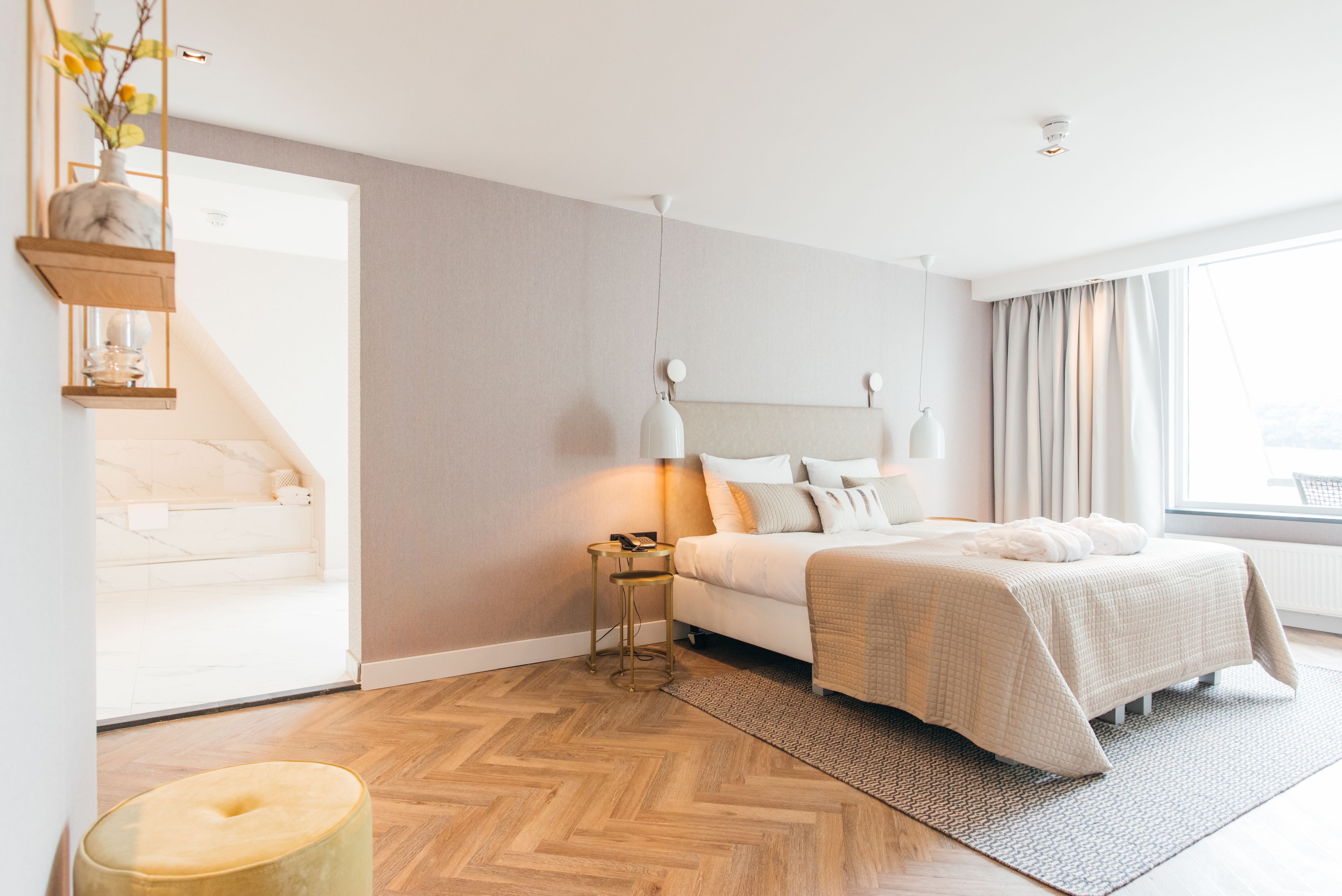 Una camera da letto moderna con un letto, comodini e una lampada a sospensione.