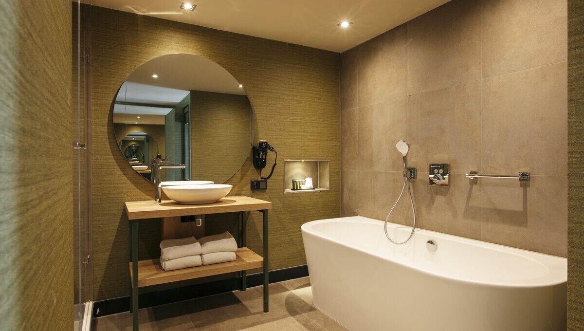 A modern bathroom with a freestanding bathtub, a vanity with a sink, and a mirror.