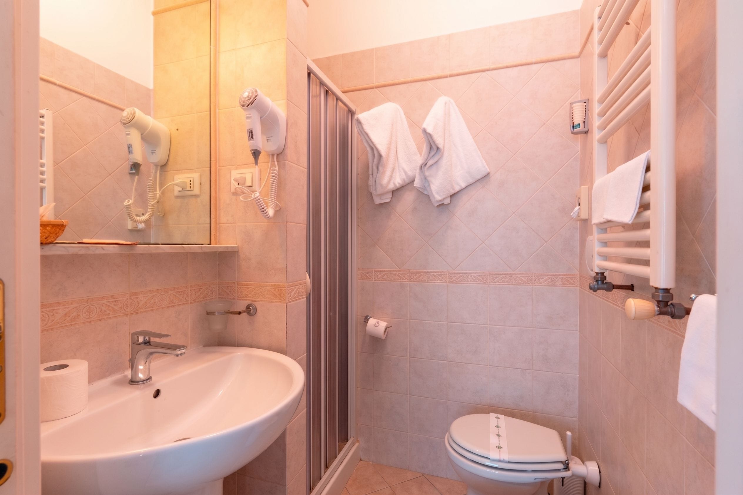 A bathroom with a sink, toilet, and a shower area.