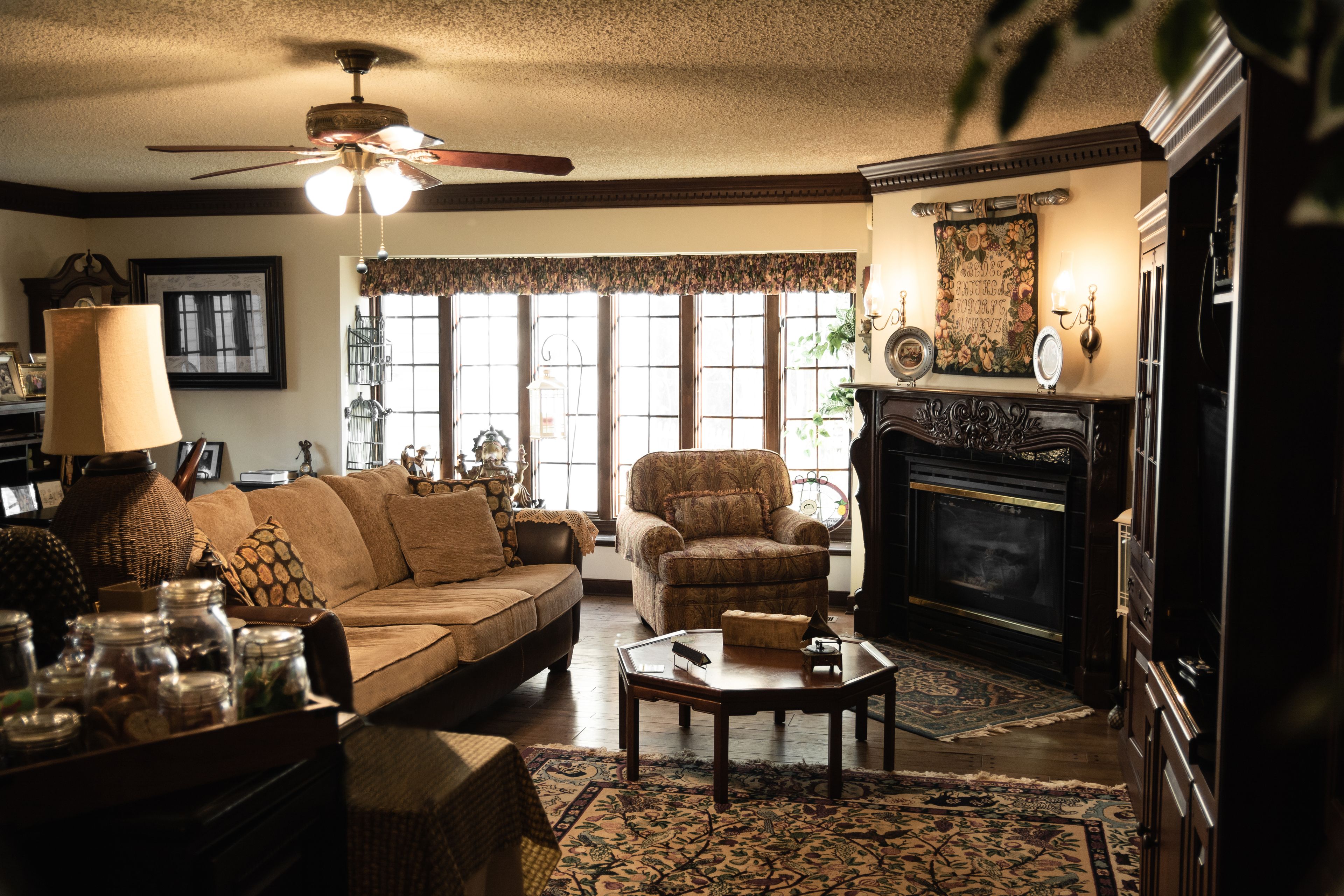 A cozy living room with a sofa, armchair, coffee table, and fireplace.
