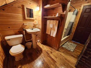 Standaard kamer | Badkamer | Een bad/douchecombinatie, een haardroger, handdoeken, zeep
