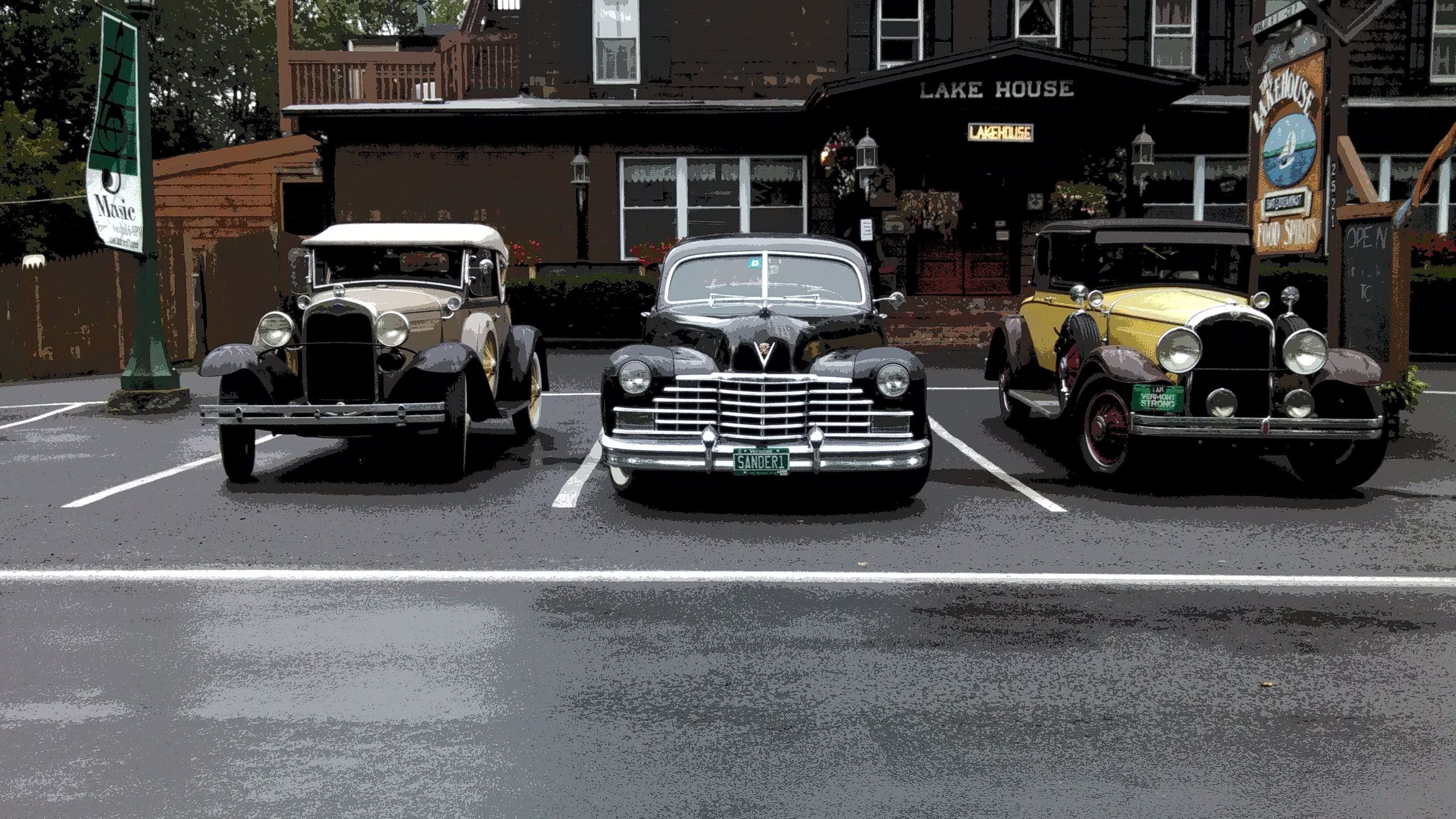 Three vintage cars parked in front of a building labeled "Lake House."