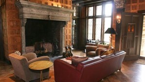 A cozy living room with a fireplace, leather sofas, and a round coffee table. - Rock Hall Luxe Lodging (Winsted)