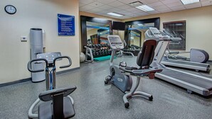 Una palestra con tapis roulant, ellittiche e pesi.
