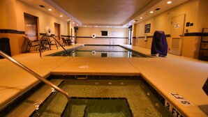 A hotel pool area with a long, narrow pool, multiple lounge chairs, and a covered seating area. - Hampton Inn & Suites Jacksonville - Beach Blvd/Mayo Clinic (Jacksonville)