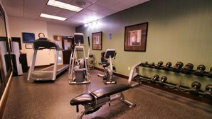 A gym with treadmills, elliptical machines, a bench press, and a rack of dumbbells. - Hampton Inn & Suites Jacksonville - Beach Blvd/Mayo Clinic (Jacksonville)