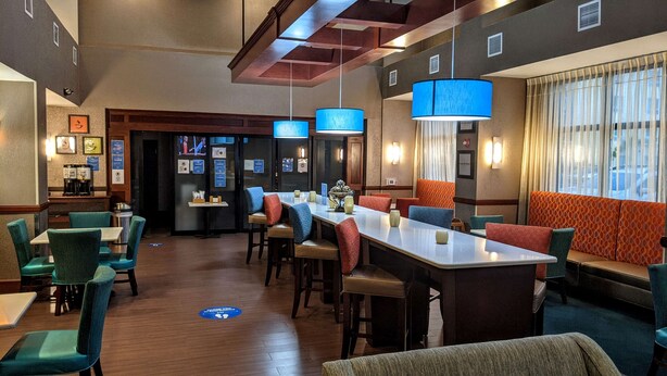 A hotel lobby with a bar area, seating arrangements, and a reception desk. - Hampton Inn & Suites Jacksonville - Beach Blvd/Mayo Clinic (Jacksonville)
