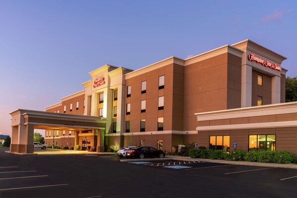 Um hotel Hampton Inn & Suites com estacionamento e entrada coberta.