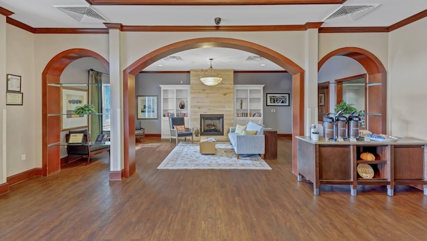A spacious living area with wooden flooring, a fireplace, a sofa, and a coffee station. - Country Inn & Suites by Radisson, Braselton, GA (Hoschton)