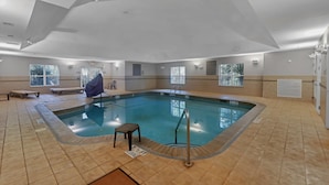 A large indoor swimming pool with a tiled floor, a pool ladder, and a bench. - Country Inn & Suites by Radisson, Braselton, GA (Hoschton)