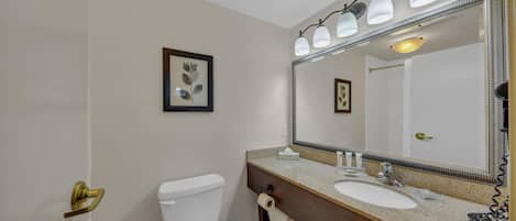 Un baño con inodoro, lavabo y espejo.