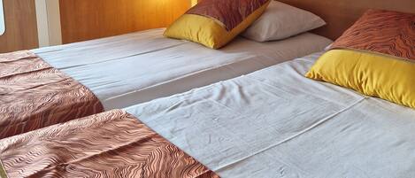 A hotel room with a bed, two pillows, and a wooden door.