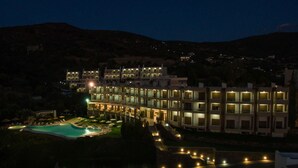 Un hotel de varios pisos con piscina y zona de estar al aire libre.