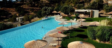 Una piscina al aire libre de temporada, sombrillas