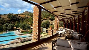 Un área junto a la piscina con mobiliario exterior y vistas a una piscina.
