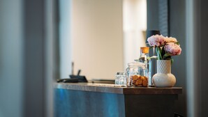Una mesa de recepción con un florero, un tarro de cristal y un pequeño recipiente.