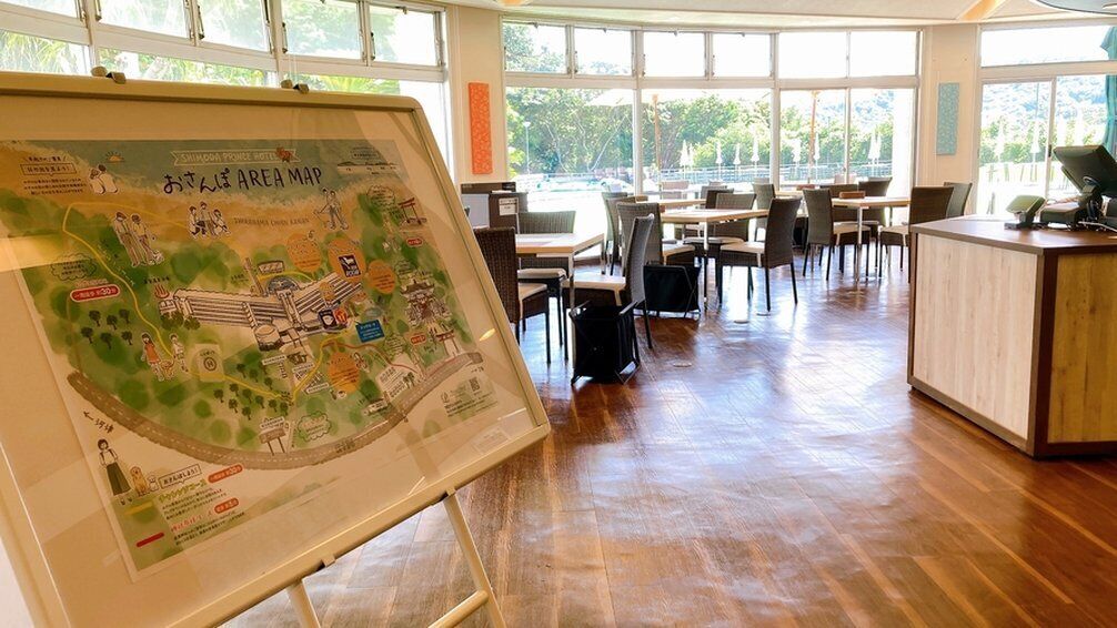 Un restaurante con un gran mapa a la vista, suelo de madera y vistas al exterior a través de amplias ventanas.