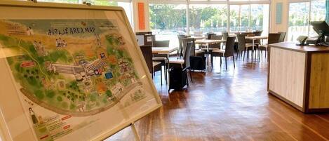 Un restaurante con un gran mapa a la vista, suelo de madera y vistas al exterior a través de amplias ventanas.