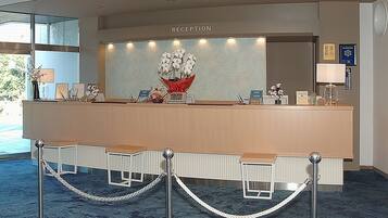 A reception area with a reception desk, nameplates, and a clock.